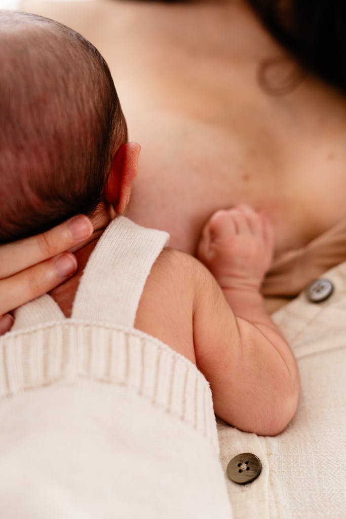 Intimate moment of a mother breastfeeding her newborn, capturing tenderness and bonding.